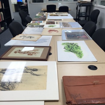 Framed images from the collection laid out on a table. 