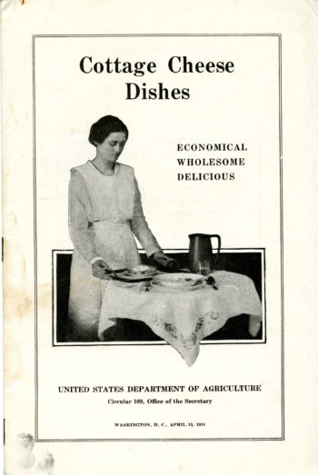 The pamphlet reads "Cottage Cheese Dishes: Economical, Wholesome, Delicious" and is marked as being from the United States Department of Agriculture. The image on the pamphlet shows a woman setting a table with what is presumedly a dish made with cottage cheese standing in substitution for meat... 