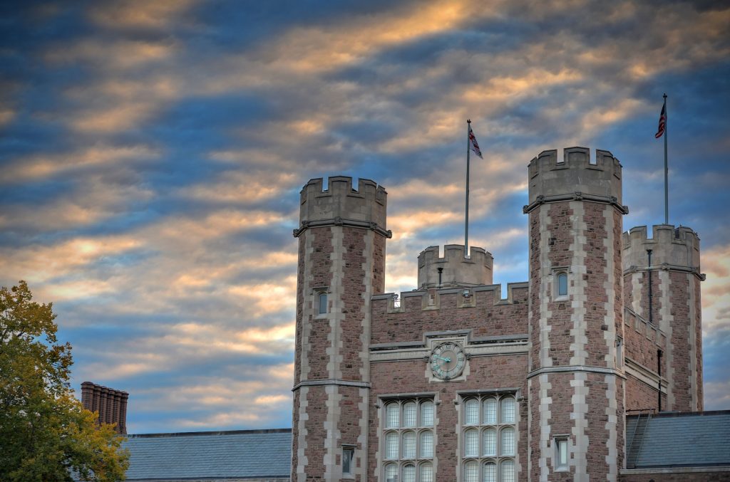 The towers of Brookings Hall against a cloudy sky at dusk. 