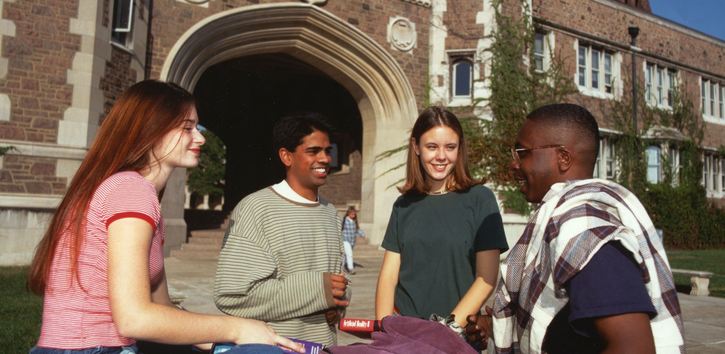 A group of four students gathered on the quad.