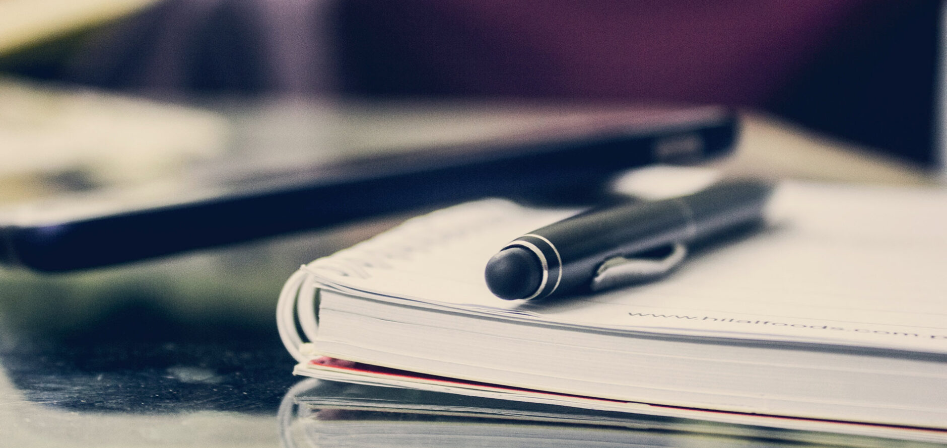 A pen resting on a notebook.