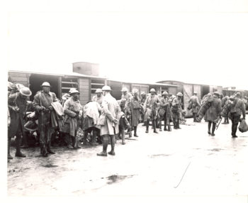 Photo of the 369th Regiment traveling in France. The image details men in uniform readying themselves to attention. 