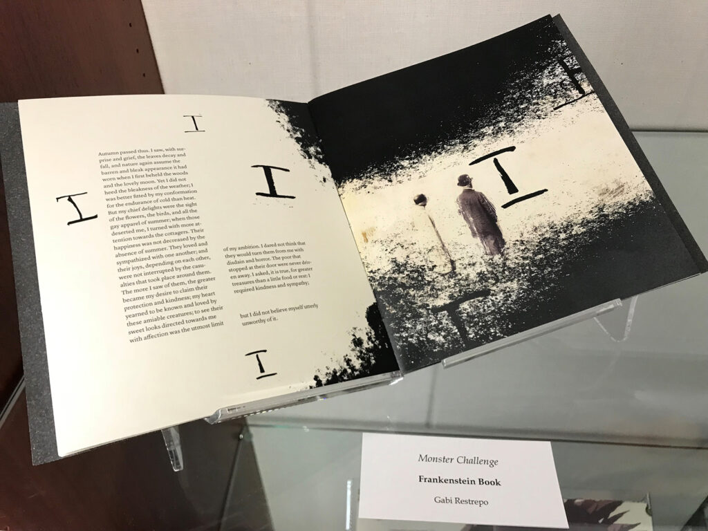 A two-page art piece with prose on the left page. The art shows a lone figure standing with the letter "I" painted around both pages. 