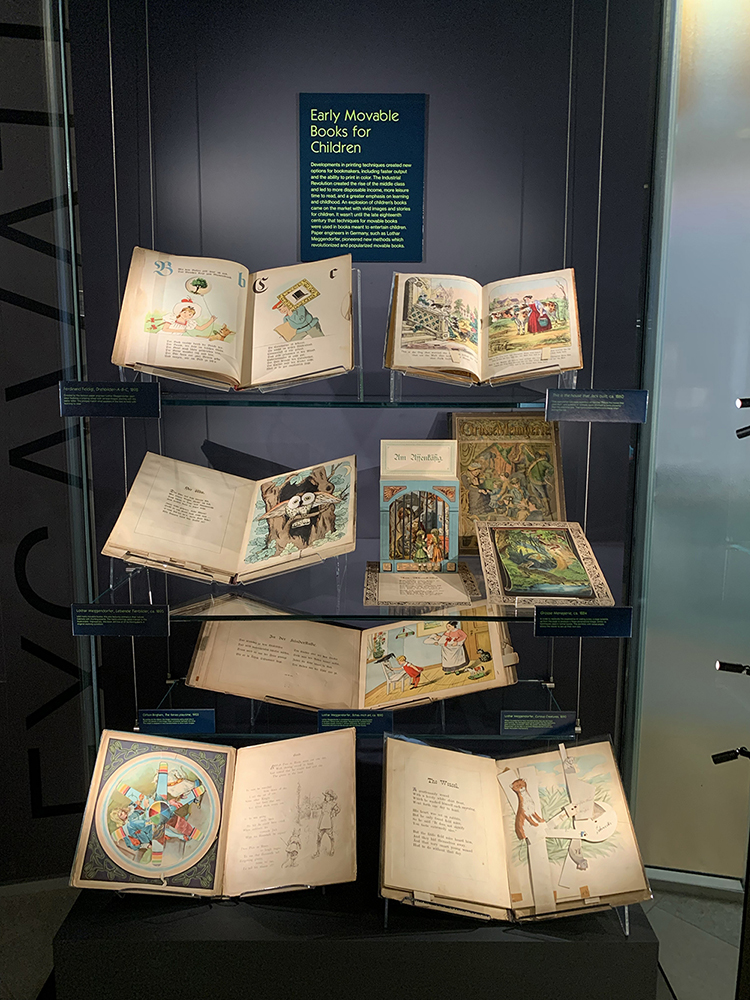 Display titled "Early Movable Books for Children" part of the Moving Magic exhibition. The display features nine older print materials with movable - not popup - parts.