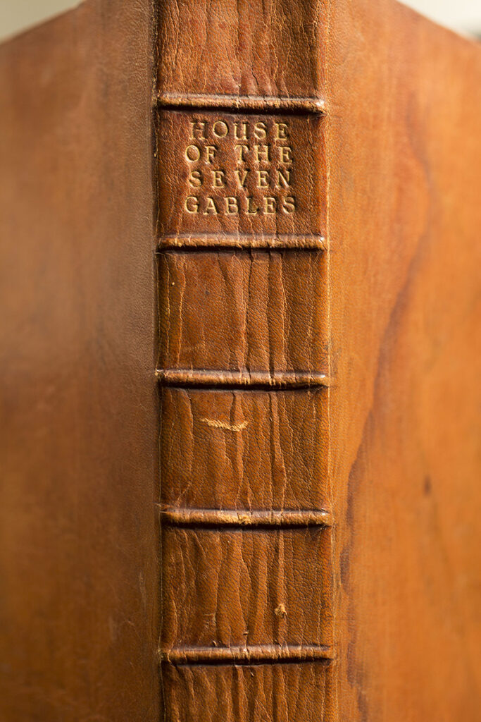 The outside spine of a leather-bound book with the title stamped. The title reads "House of the Seven Gables."
