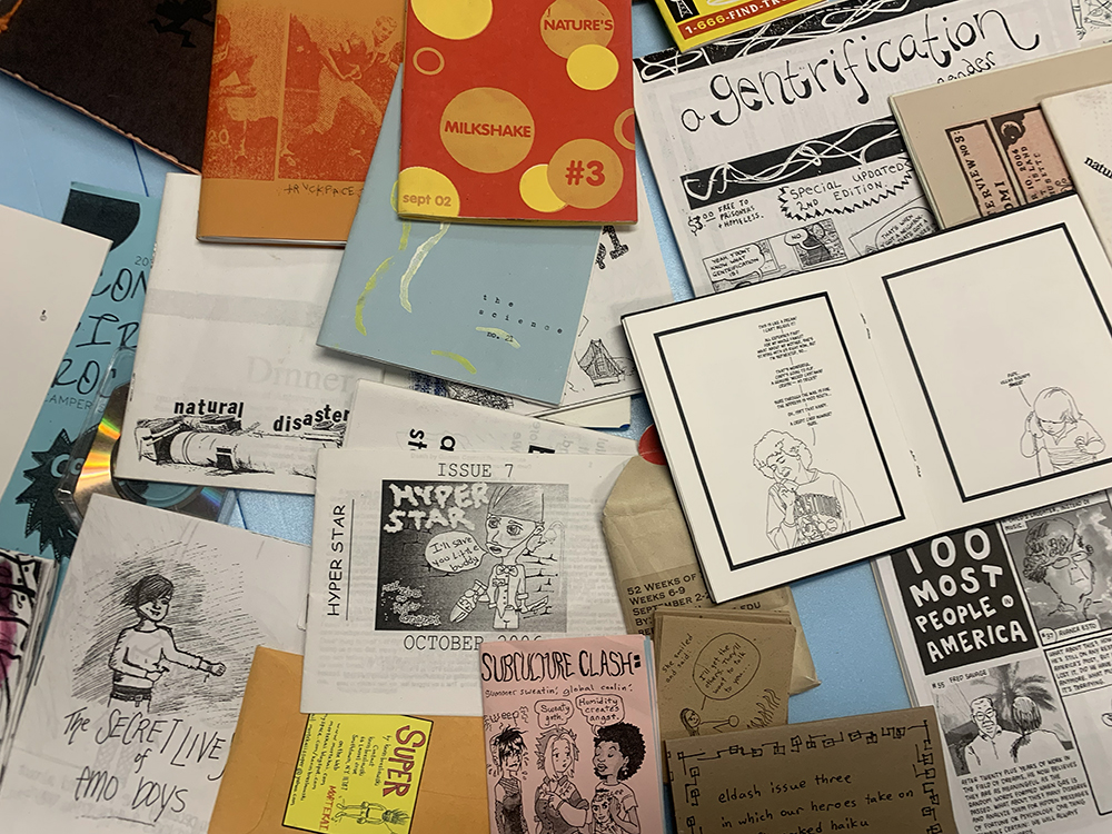 A collage of many, many different zines showcased in the Ideas, Art, and Community Collect O'Rama exhibition case.