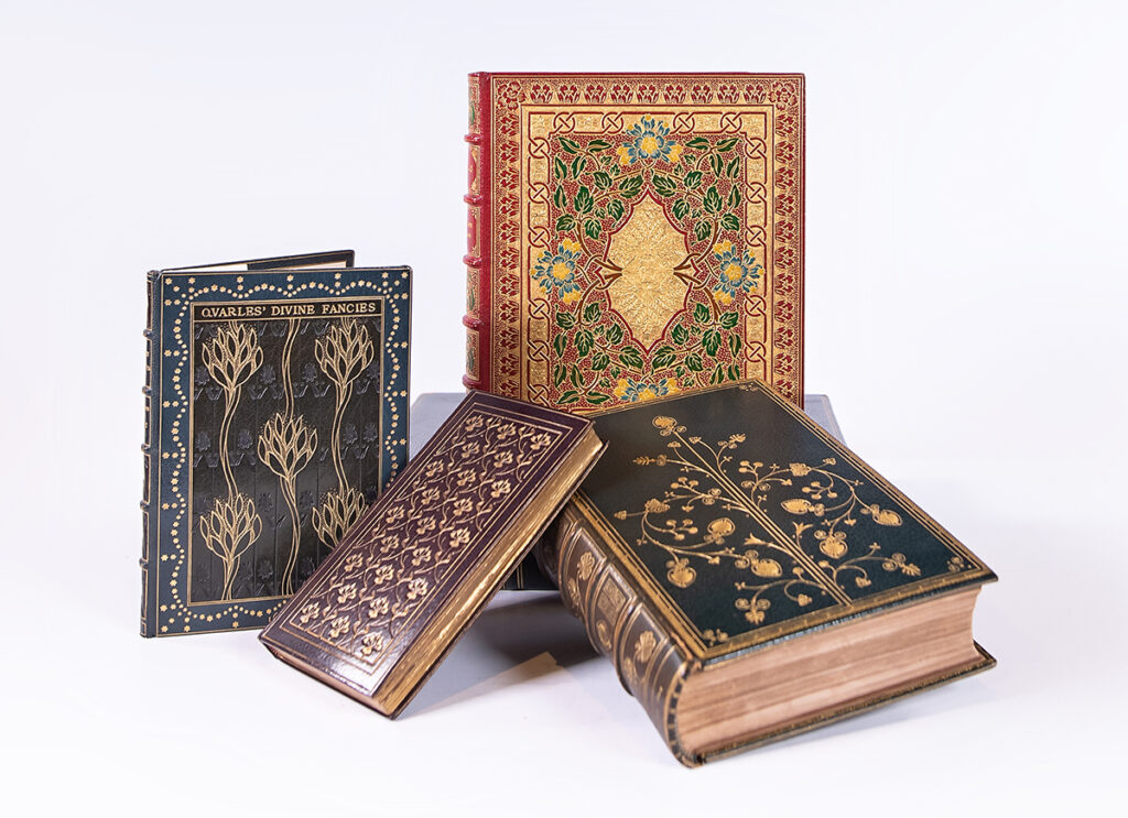 Four books with beautifully intricate designs etched into the leather book covers.