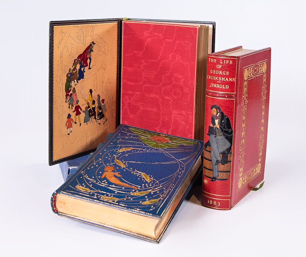 Colorful designs and illustrations etched into the outer and inner leather book covers on three texts.