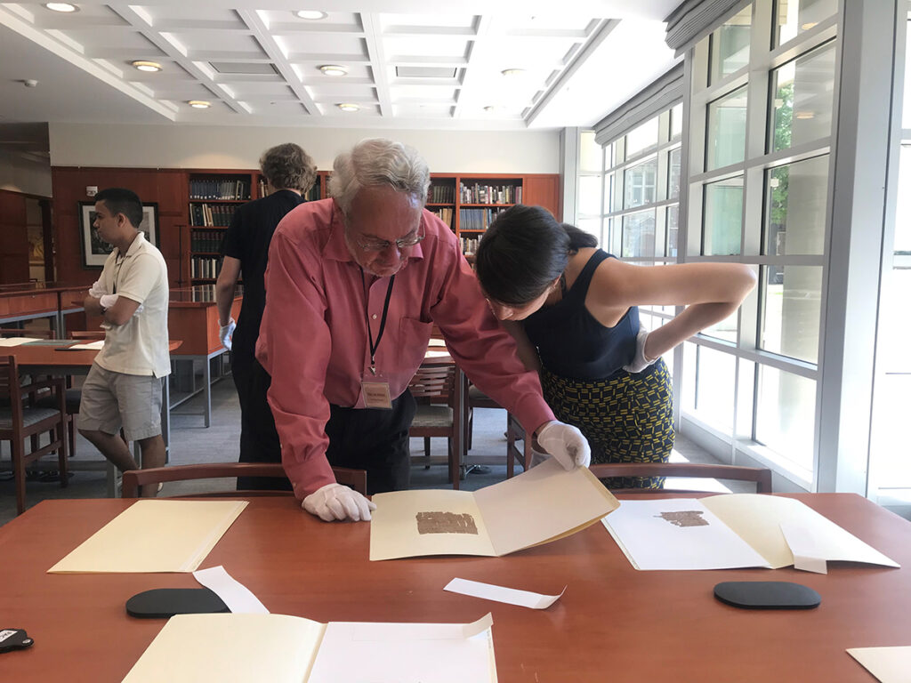 A professor and student look over some of the papyri collection documents.