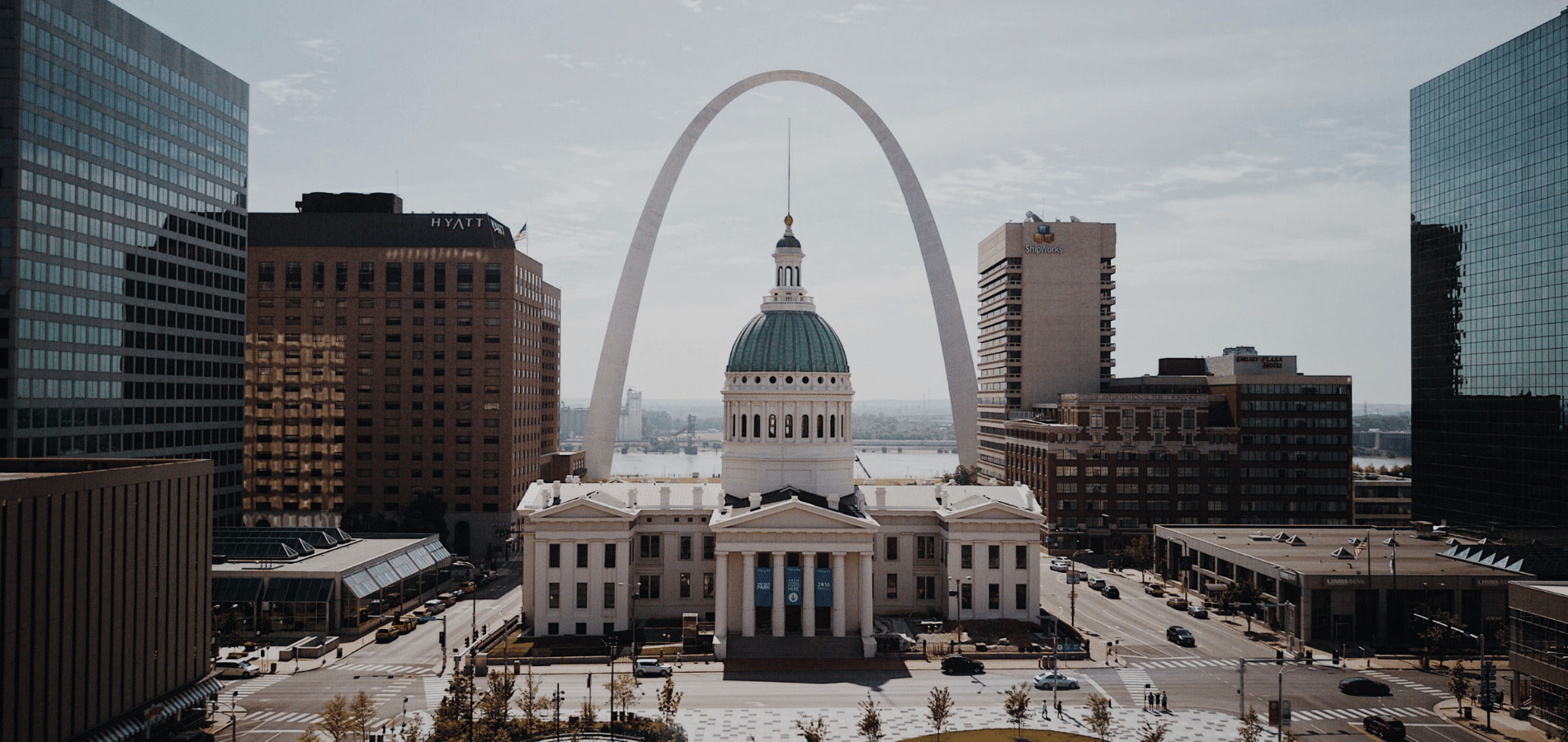 A photo of the St. Louis Courthouse with the Arch in the background.