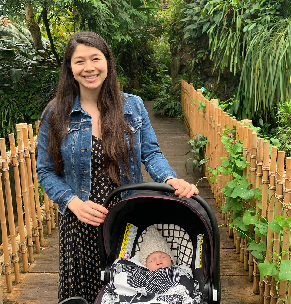 Neureuther awardee Clarissa Tardiff standing with baby amid green foliage