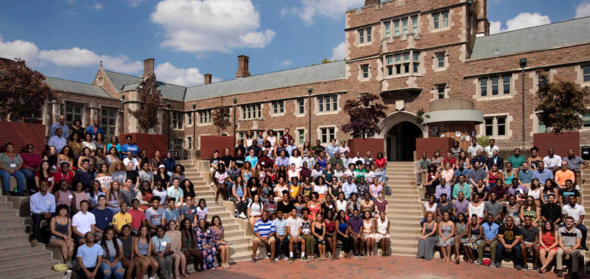 At least a hundred Ervin Scholars sitting for a photo outside on the Washington University in St. Louis campus.