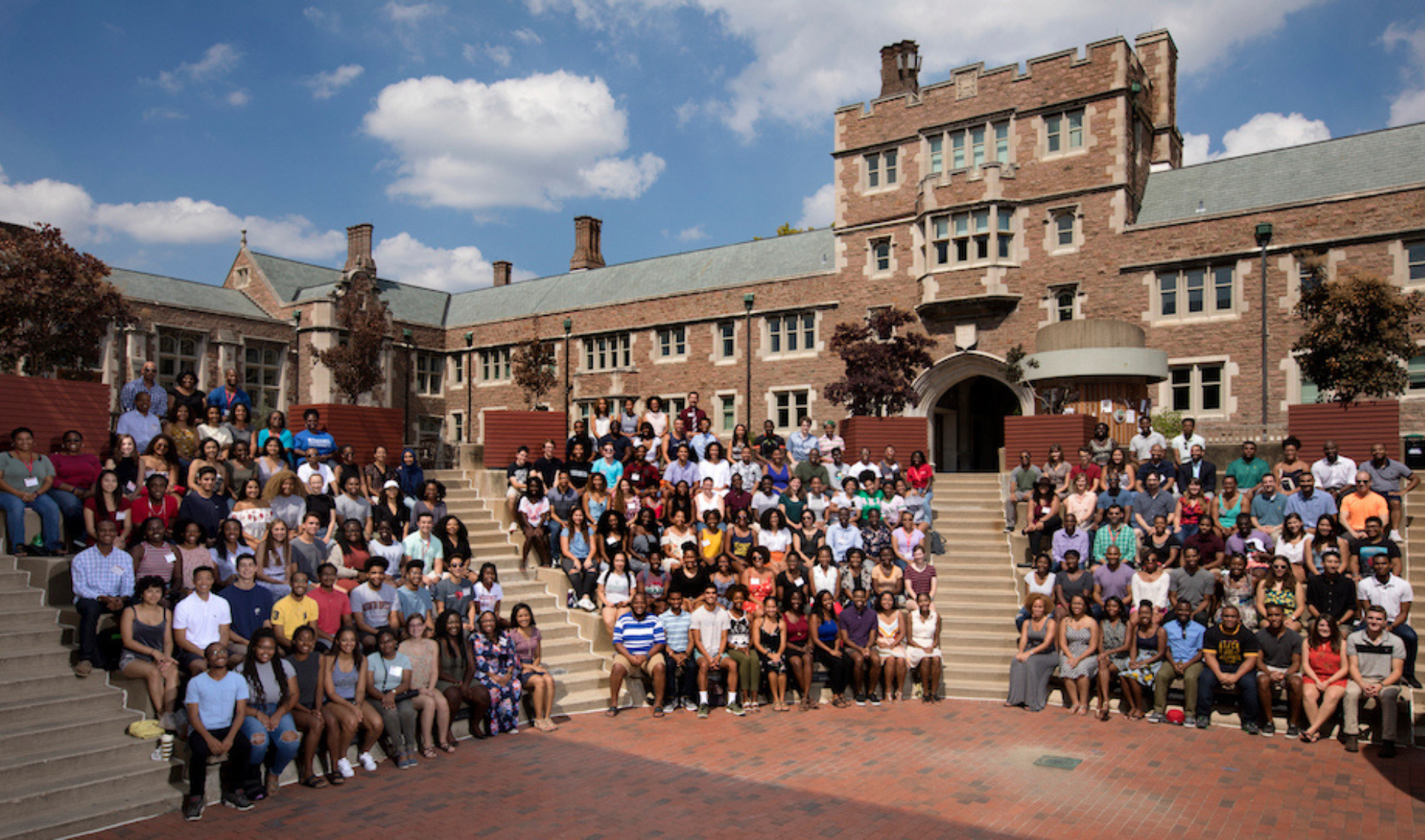 At least a hundred Ervin Scholars sitting for a photo outside on the Washington University in St. Louis campus.