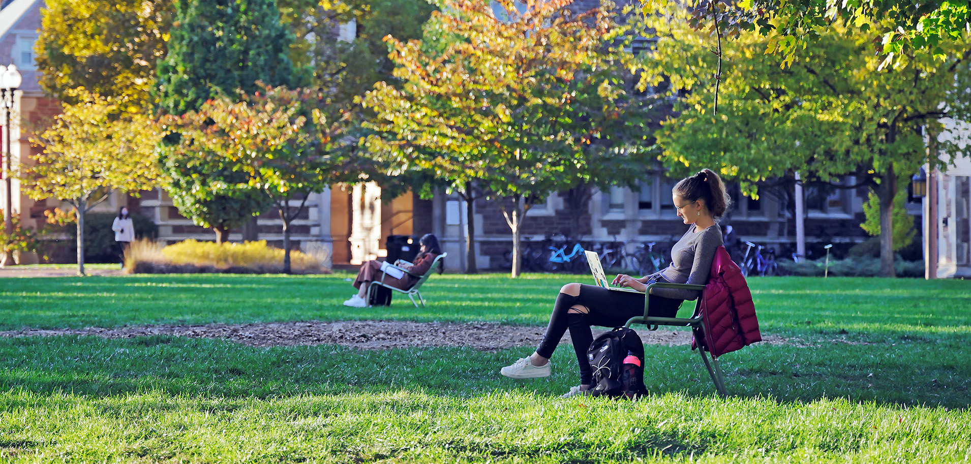 Students relaxing and studying in chairs on the Danforth Campus lawns.