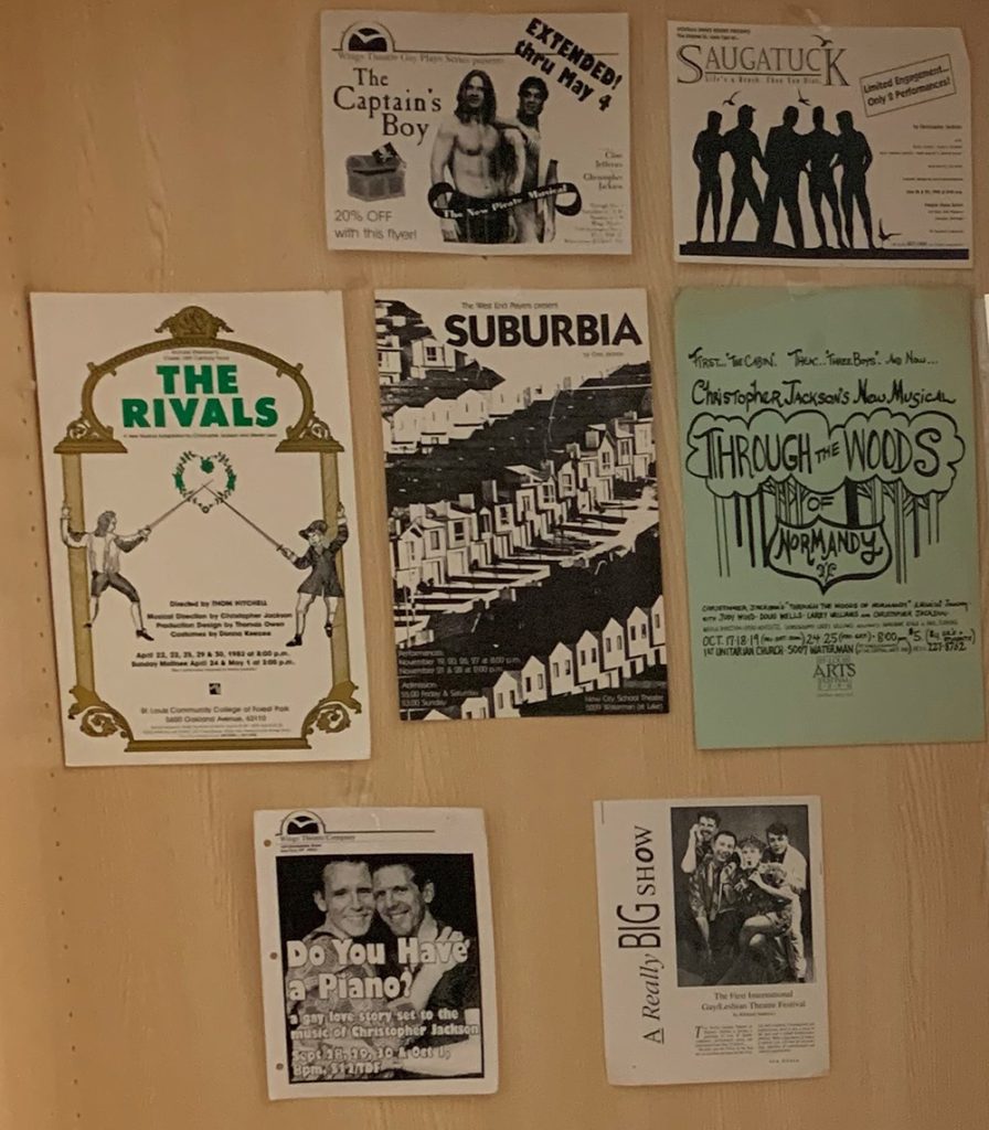 Seven paper posters on a wall. For theatrical productions of The Captain’s Boy, Saugatuck, The Rivals, Suburbia, Through the Woods of Normandy, Do You Have a Piano?, and A Really Big Snow.
