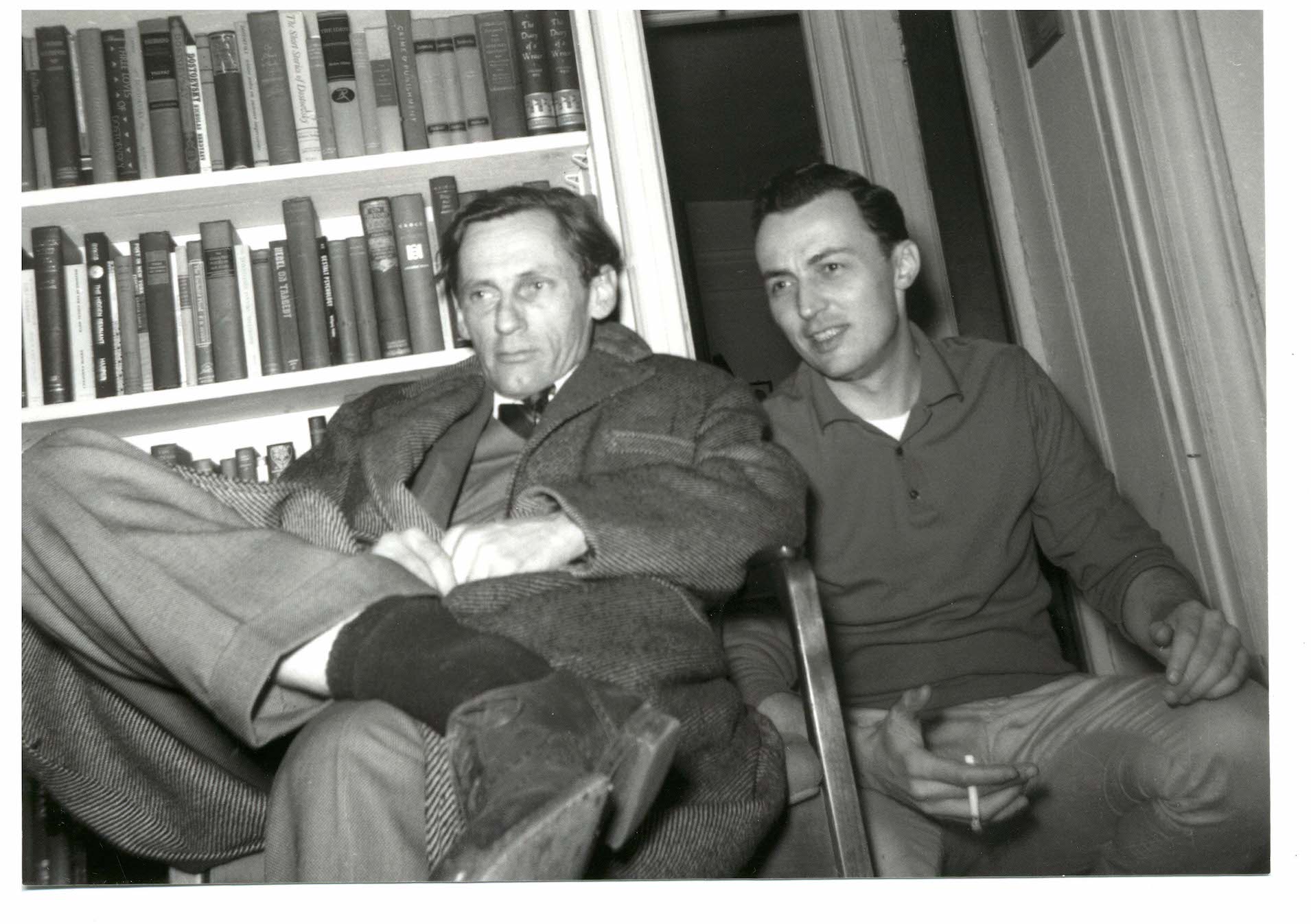Two men sitting in front of a bookcase