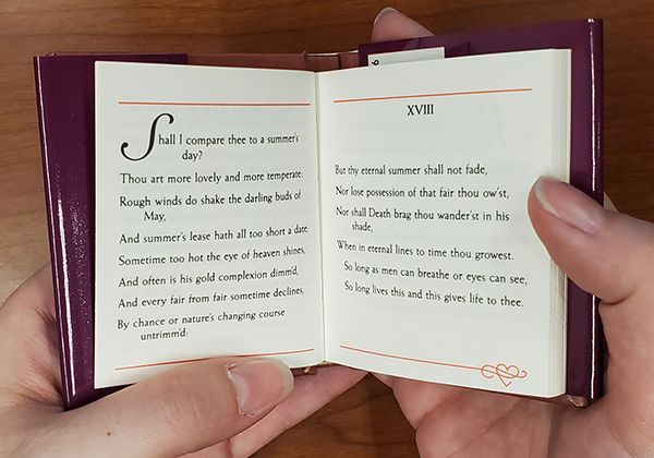 The miniature book of Love Sonnets by Shakespeare open to Sonnet XVIII, which begins with the question "Shall I compare thee to a summer's day?"