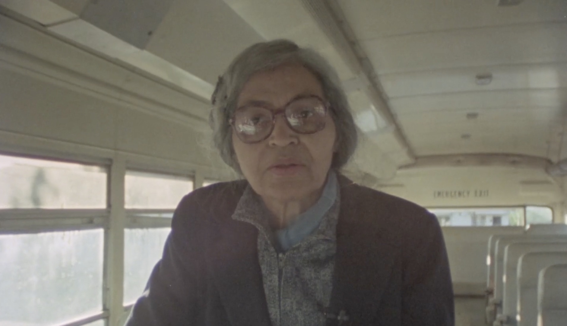 An elderly woman inside an empty bus