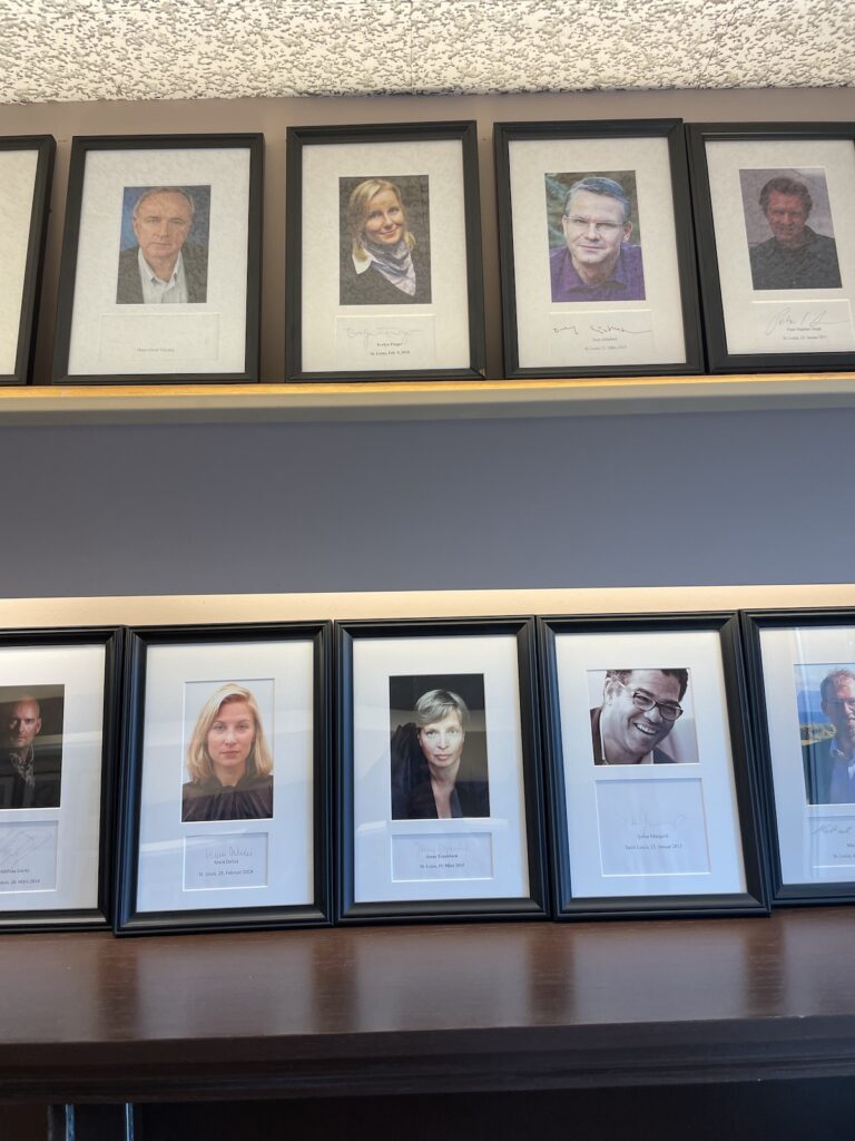 Two rows of photos of peoplemounted on shelves