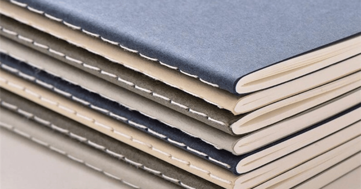 Saddle-stitched journals in a stack.