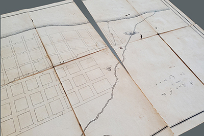 An undetailed map of the town of Saint Louis circa 1819 with a large tear through one of the folded sections.