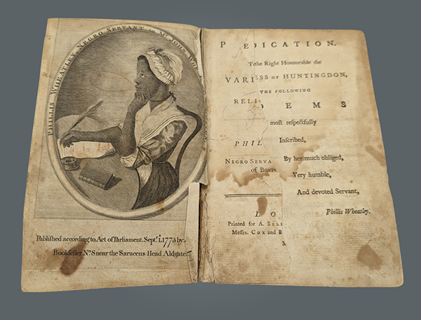 The image shows an open page of Phillis Wheatley's Poems on Various Subjects. On the left is an illustration of the author sat writing at a table and the right is the publication page.
