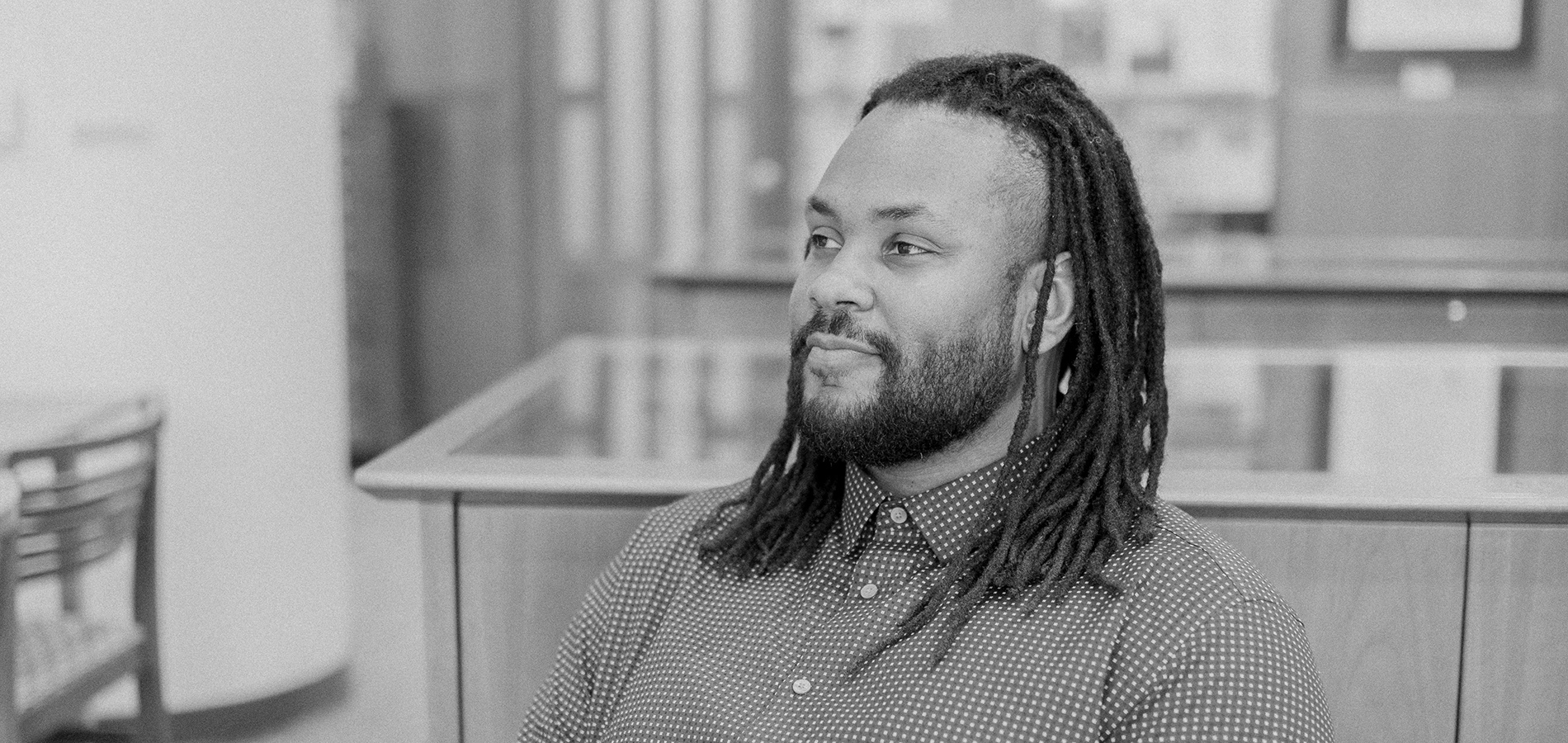 A photo of poet Aaron Coleman seated within the Olin Library Special Collections Reading Room.