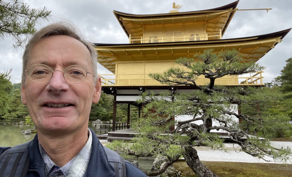 Man in front of a temple made of gold.