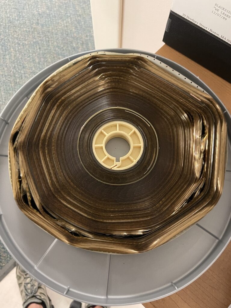 Darkened reel of film in plastic container