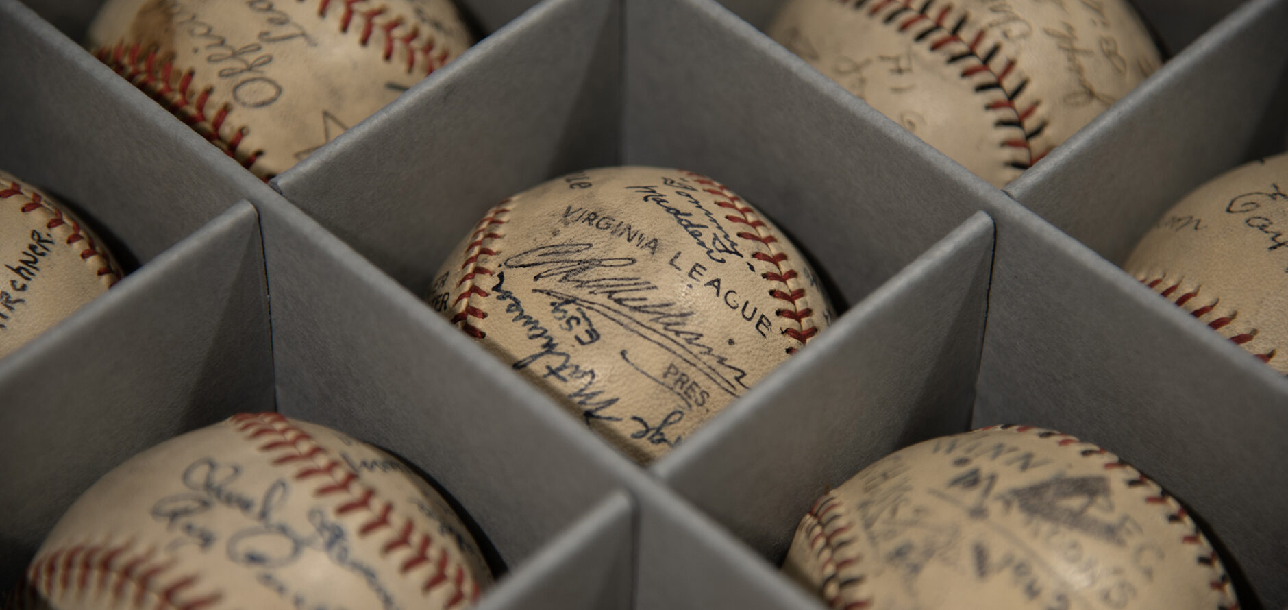 Signed game day baseballs individually stored in a preservation box.