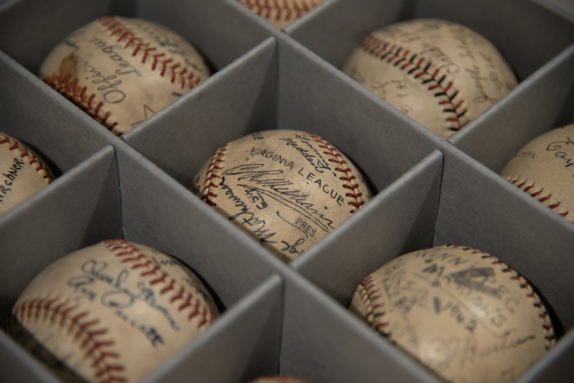 Signed game day baseballs individually stored in a preservation box.
