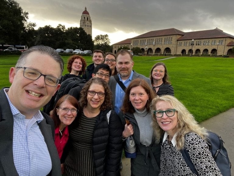 A group of people on a grassy lawn at Stanford.