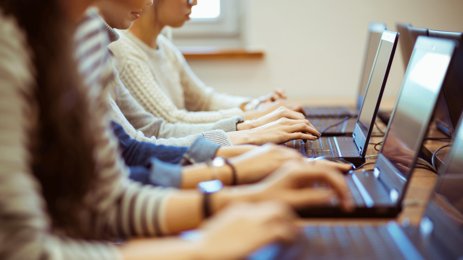 Students typing on laptop computers