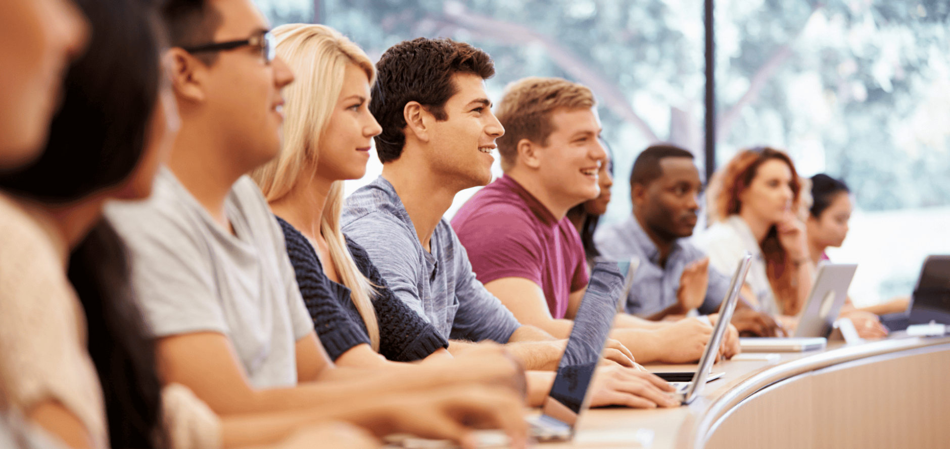 Group of college students using laptops in lecture