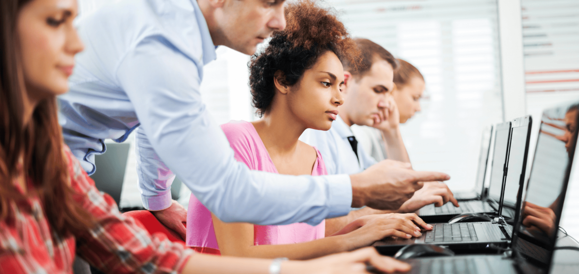 Stock photo of professor assisting a student on a laptop