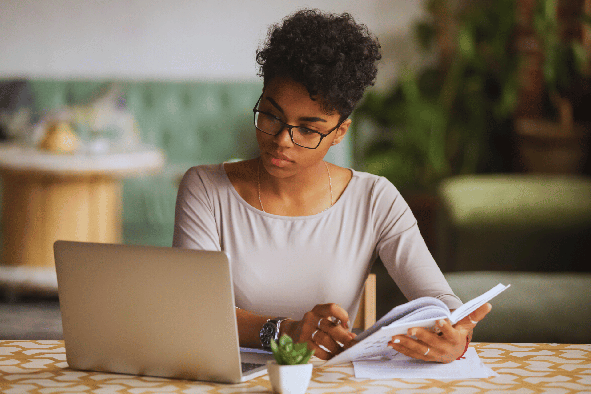 Stock photo of student writing in notebook and looking at laptop computer