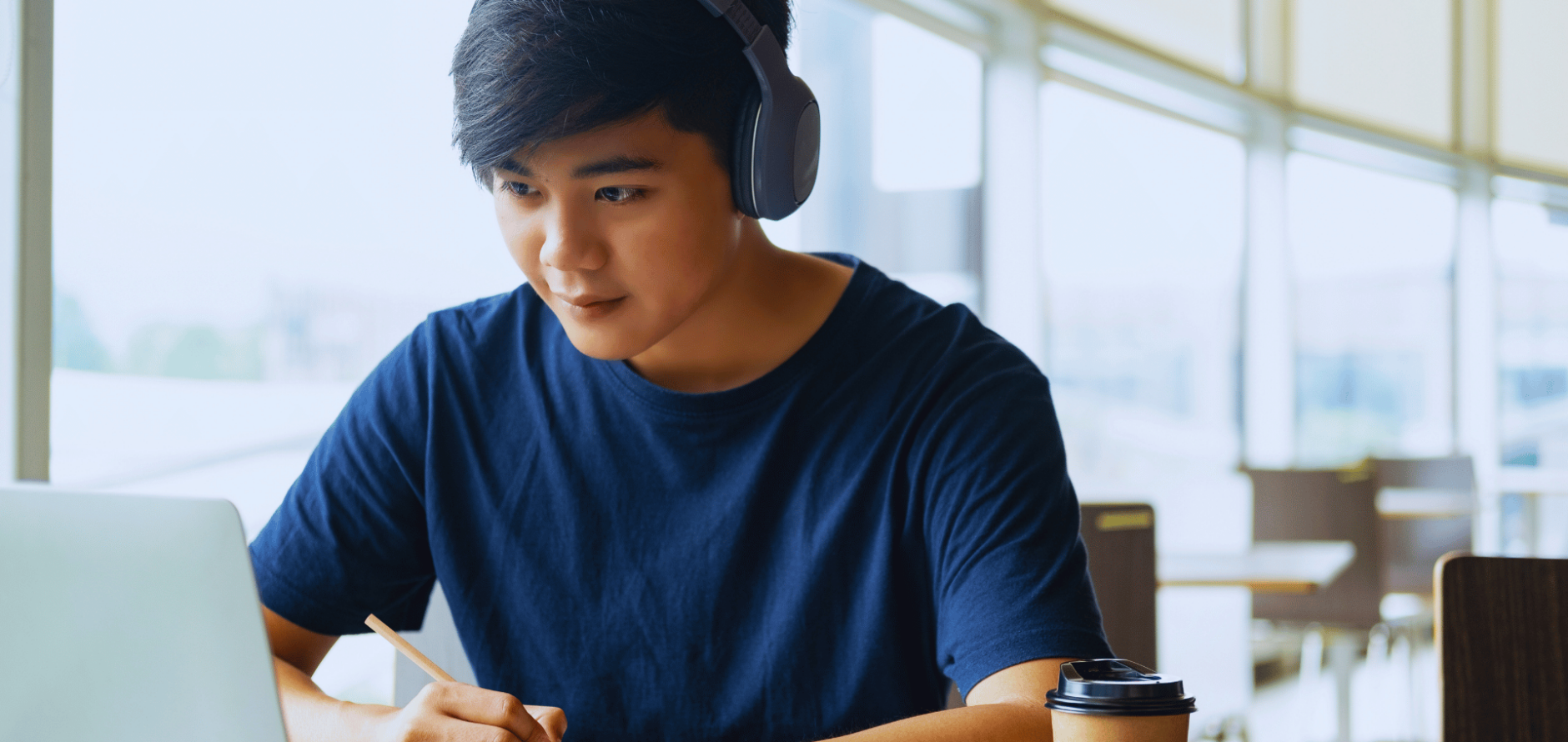 Student looking at laptop with headphones on